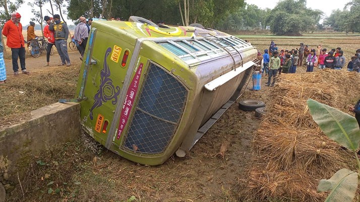 The passenger bus overturned on the paddy field after the wheel slipped in the mud, injuring 12 passengers