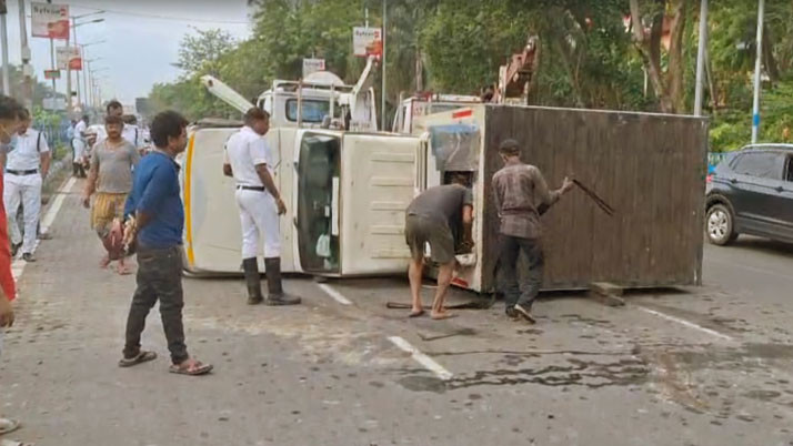Milk cart overturns on wet road in the morning